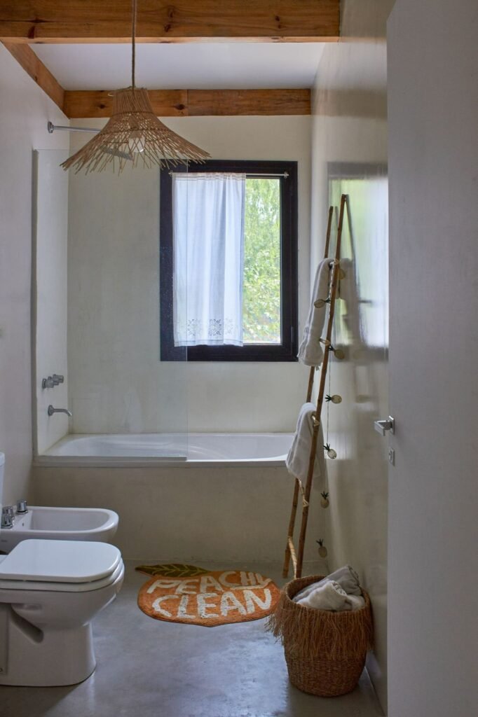 baño con revestimiento de microcemento y vigas de madera